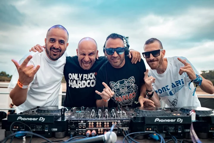 DJ Sisu, DJ Sonic, Xavi Metralla y DJ Skudero junto a equipo de DJ en una fotografía promocional al aire libre.